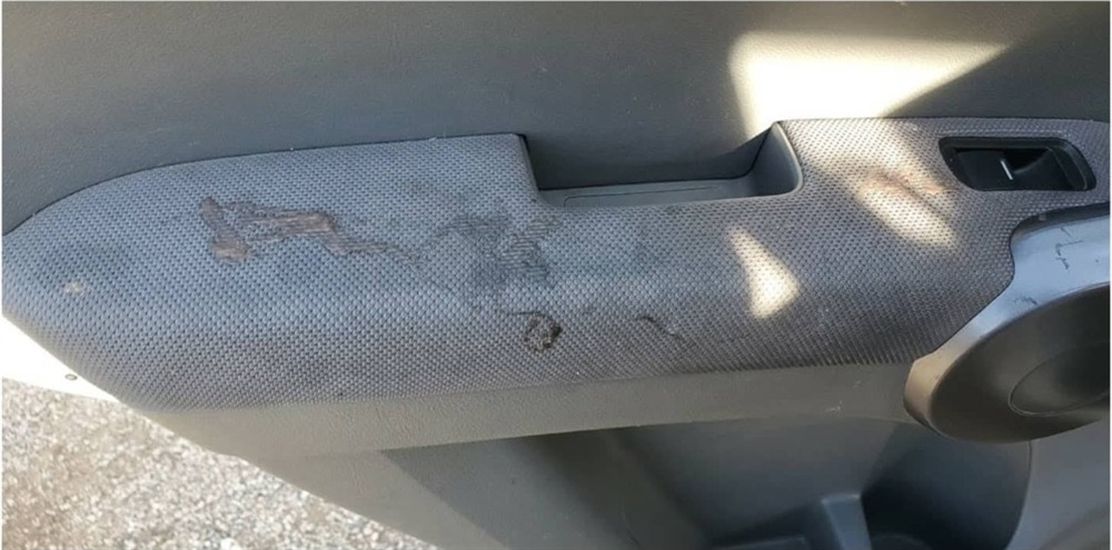 Car center console and armrest with body grease and dirt before cleaning